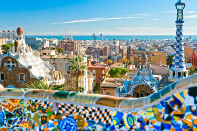 Panoramic view of Barcelona from Park Güell, showcasing vibrant mosaics and urban skyline, highlighting the city's architectural beauty relevant to potential Spanish Grand Prix travel packages.