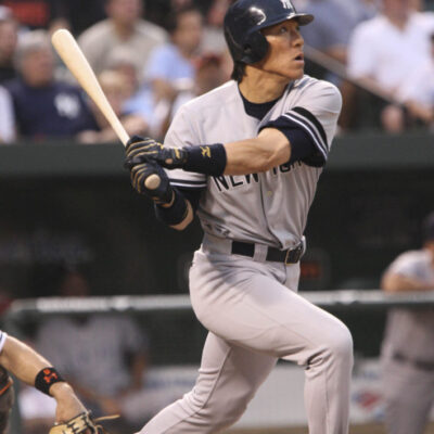 A baseball player in a New York uniform swings at a pitch during a game, capturing the excitement typical of World Series events, perfect for those considering luxury travel packages.
