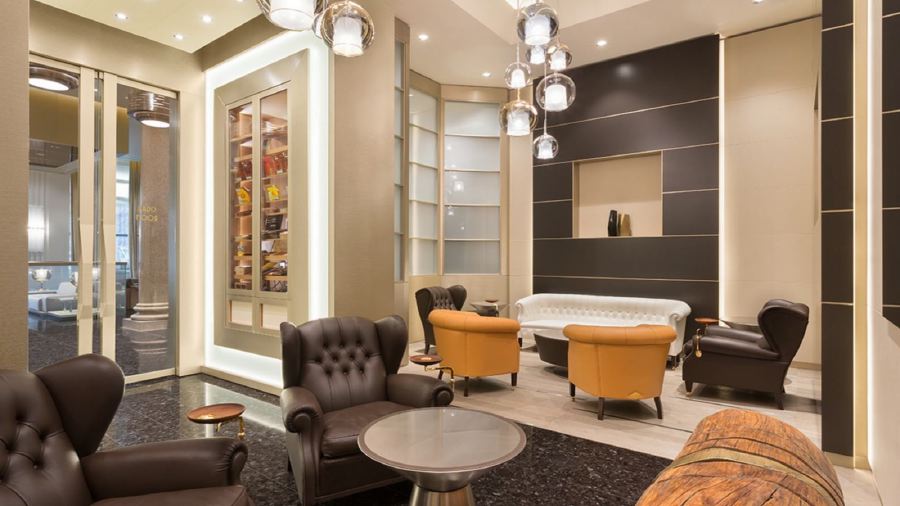 Elegant interior of Excelsior Hotel Gallia in Milan, featuring a sophisticated lounge area with leather chairs and chic lighting, ideal for guests visiting during the Italian Grand Prix.