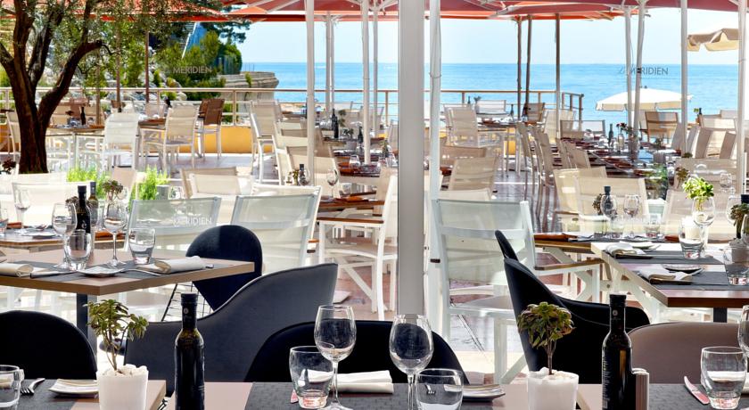 Ocean-view dining setup at Le Meridien Beach Plaza in Monaco, showing elegantly arranged tables with glassware, under a shaded patio, perfect for the Monaco Grand Prix.