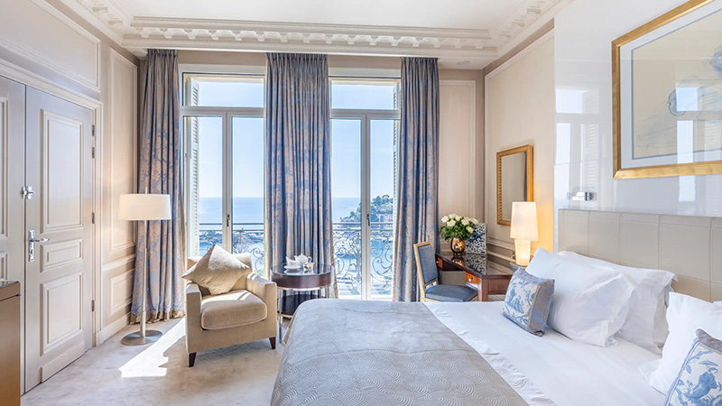 Luxurious hotel room at Hotel Hermitage in Monaco, featuring elegant decor, a balcony overlooking the sea, ideal for Monte Carlo accommodation options near the Monaco Grand Prix.