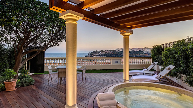 Luxurious terrace at Hotel Hermitage in Monaco featuring a hot tub, comfortable loungers, and a scenic view of Monaco's coastline, perfect for Grand Prix accommodations.