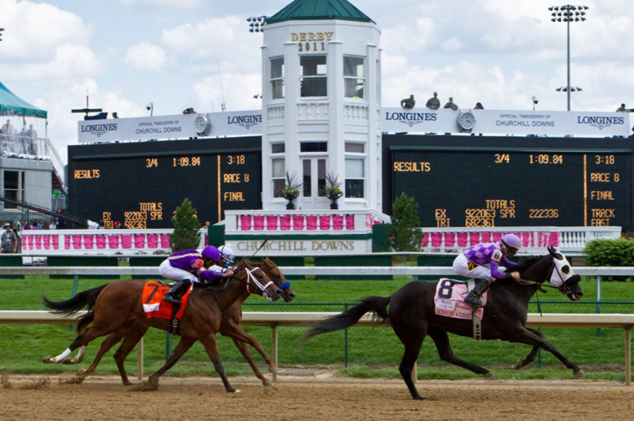 Two horses with their jockeys race on the tracks at Churchill Downs during the Kentucky Derby, a central event in luxury sports travel guides.
