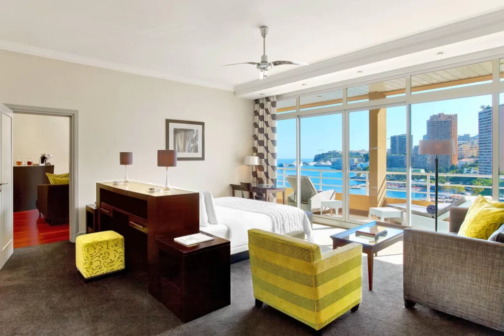 Luxurious hotel suite at Le Meridien Beach Plaza in Monaco, featuring stylish furniture and panoramic views of Monaco's coastline, ideal for Monte Carlo Grand Prix accommodations.
