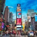 Vibrant scene at Times Square, New York, filled with pedestrians and bright digital billboards, showcasing an ideal setting for sports travel packages and luxury tours.
