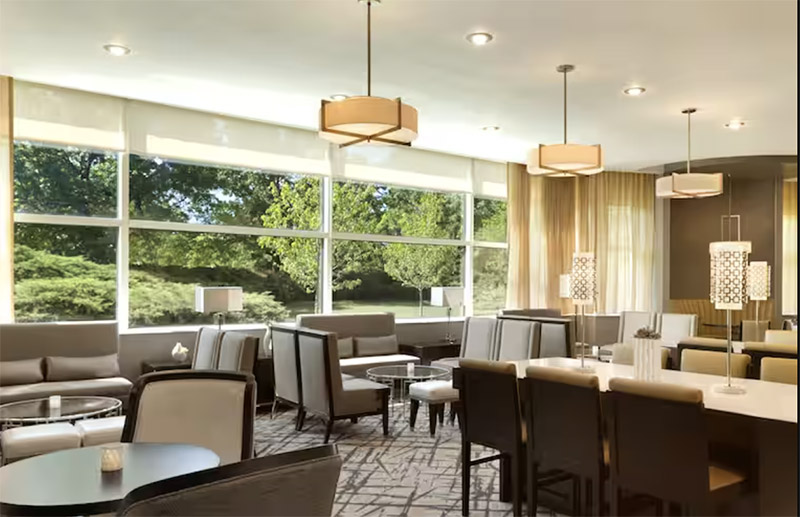 Bright, modern lounge area at The Park Hotel at Meadowlands featuring elegant seating, decorative lighting, and large windows overlooking greenery, ideal for World Cup travel accommodations.