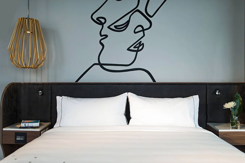 Elegant hotel room with twin beds, sophisticated decor, and modern amenities, perfect for guests attending the Canadian Grand Prix in Montreal, Quebec.
