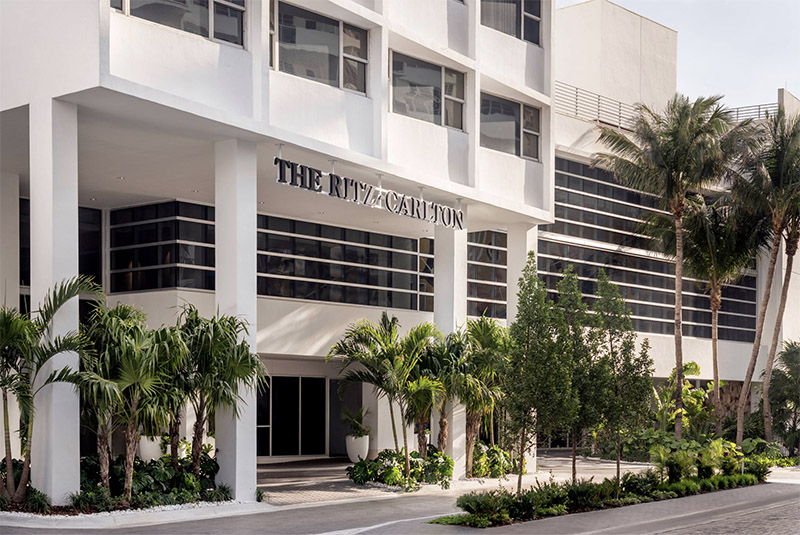 Exterior view of The Ritz-Carlton hotel in Miami Beach, surrounded by palm trees, ideal for Club World Cup hotel accommodations.