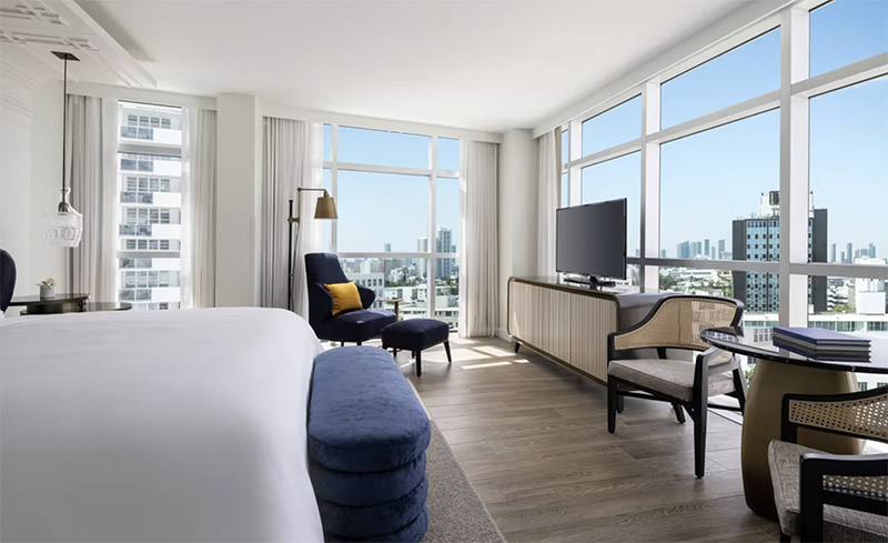 Spacious hotel room at The Ritz-Carlton, South Beach featuring modern furnishings, panoramic city views from floor-to-ceiling windows, ideal for Club World Cup accommodations in Miami.