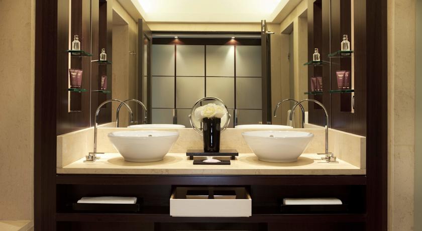 Elegant bathroom in a luxury hotel featuring dual sinks, marble countertops, and modern amenities, ideal for guests attending the Spanish Grand Prix in Barcelona.