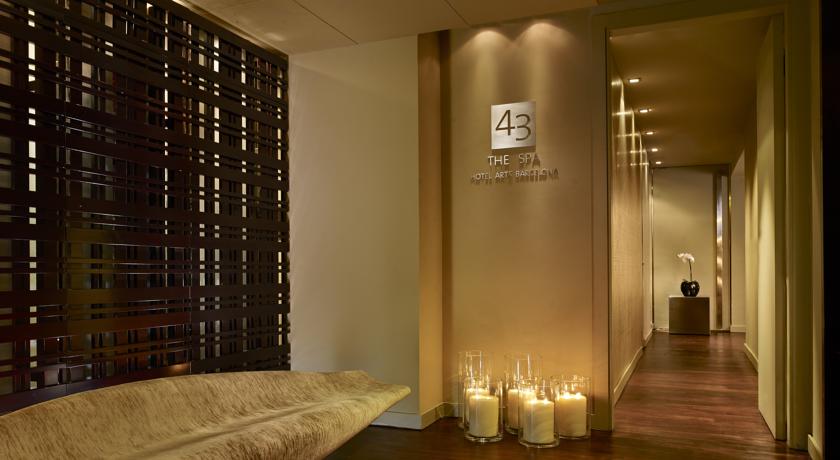 Elegant hallway of The Spa at Hotel Arts Barcelona illuminated by candles, showcasing modern design and tranquil ambiance, ideal for guests attending the Spanish Grand Prix.
