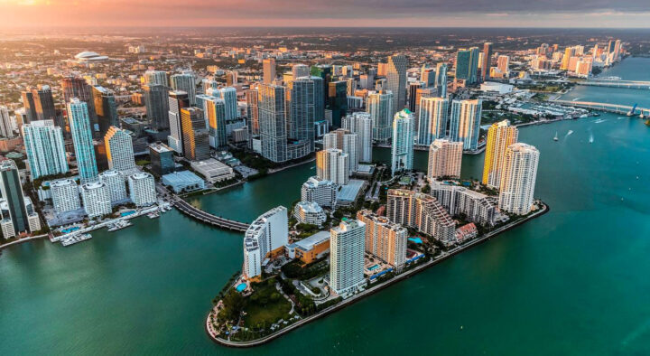 Aerial view of Miami showcasing densely packed skyscrapers along the coastline, highlighting the city's vibrant architecture and waterfront setting, ideal for discovering and planning roadtrips.