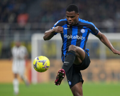A soccer player in a blue and black striped jersey controls the ball during a match, illustrating the dynamic action typical at the Champions League Final events.