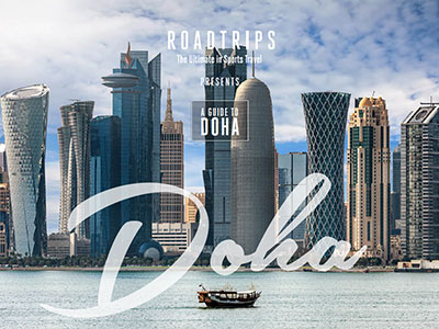 A traditional boat sails in front of the modern skyline of Doha, featuring the Roadtrips logo and promoting a luxury travel guide to the city.