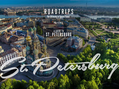 Aerial view of St. Petersburg featuring prominent buildings and green landscapes, marketed as a luxury travel guide by Roadtrips, focusing on sports travel.