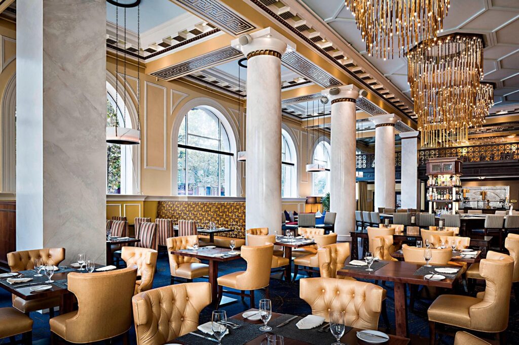 Elegant dining area in Hotel ICON, featuring classic architecture with modern chandeliers, ideal for World Cup visitors seeking upscale accommodations in Houston, Texas.